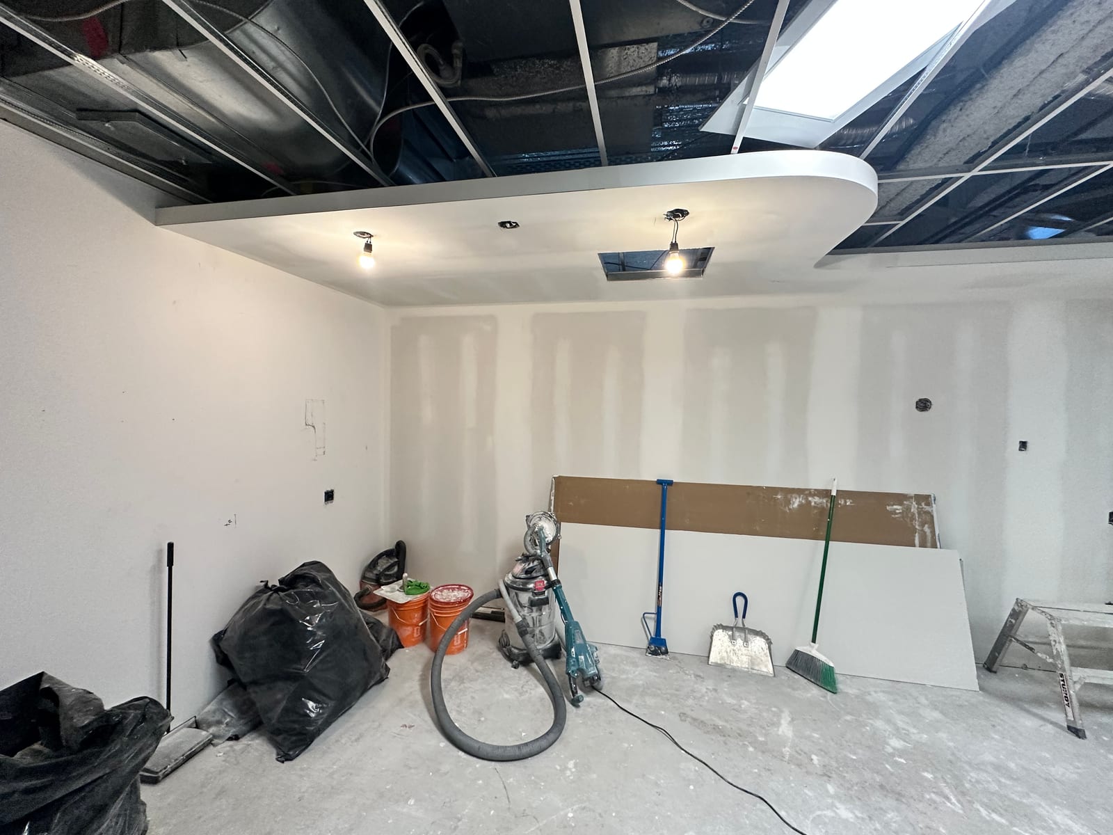 Curved bulkhead and mudded drywall with T-bar grid above