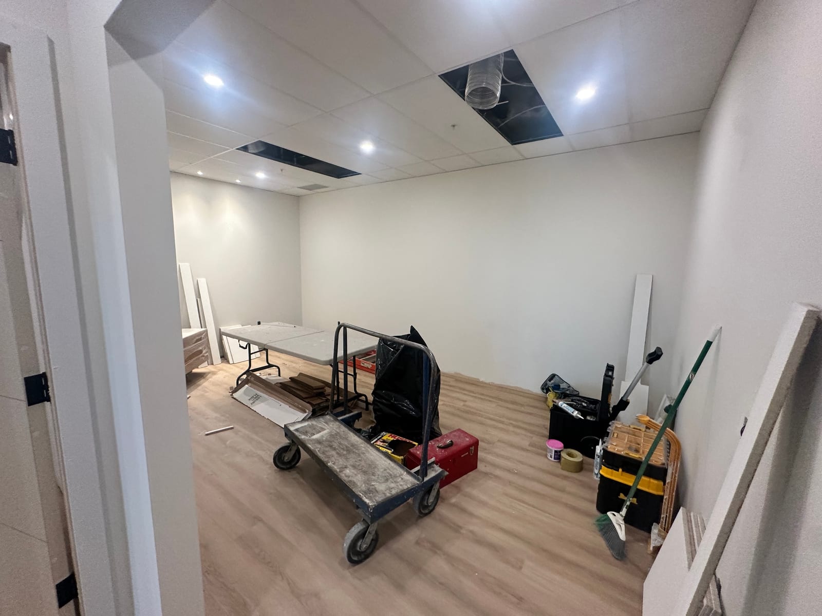 Room with T-bar ceiling, finished drywall walls, and work in progress