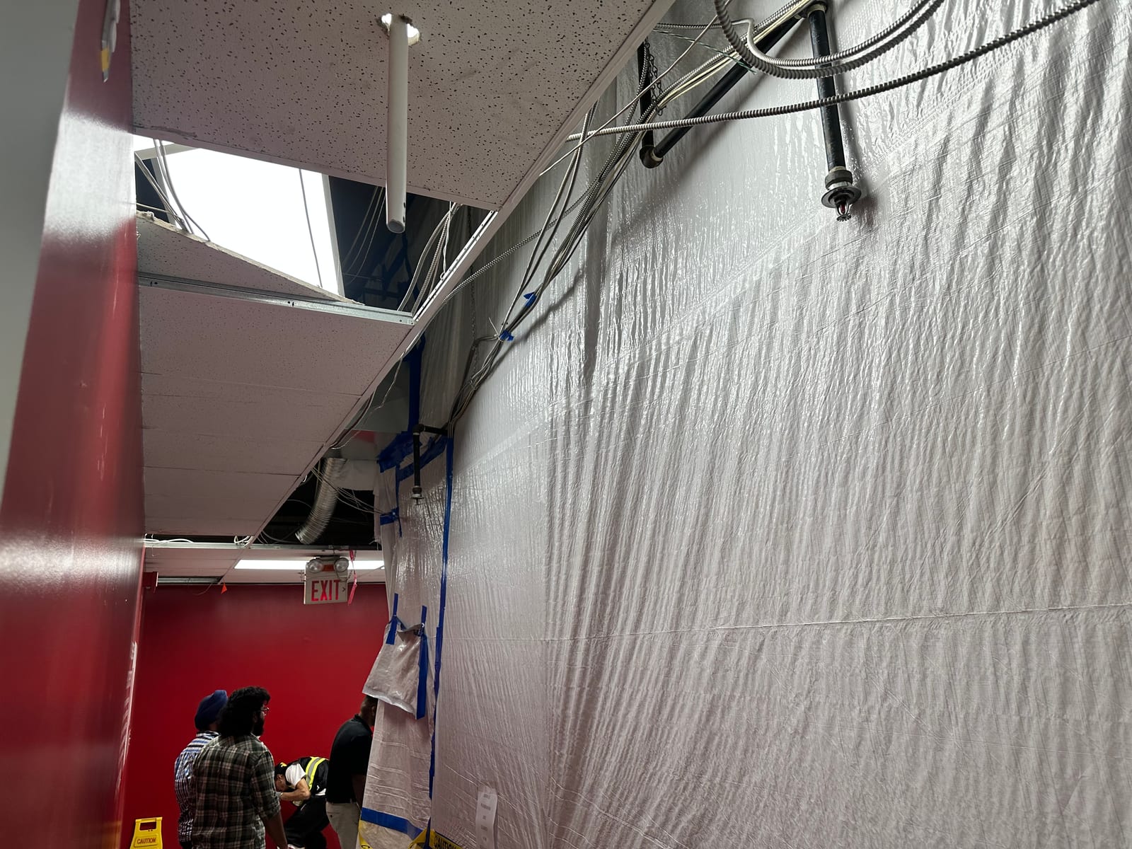 Partial T-bar grid with exposed conduit and sprinkler during install