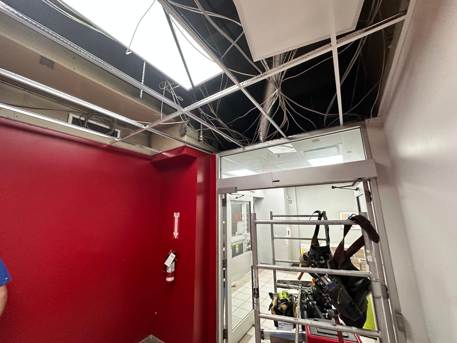 T-bar ceiling install in progress with tiles, lights, and scaffold