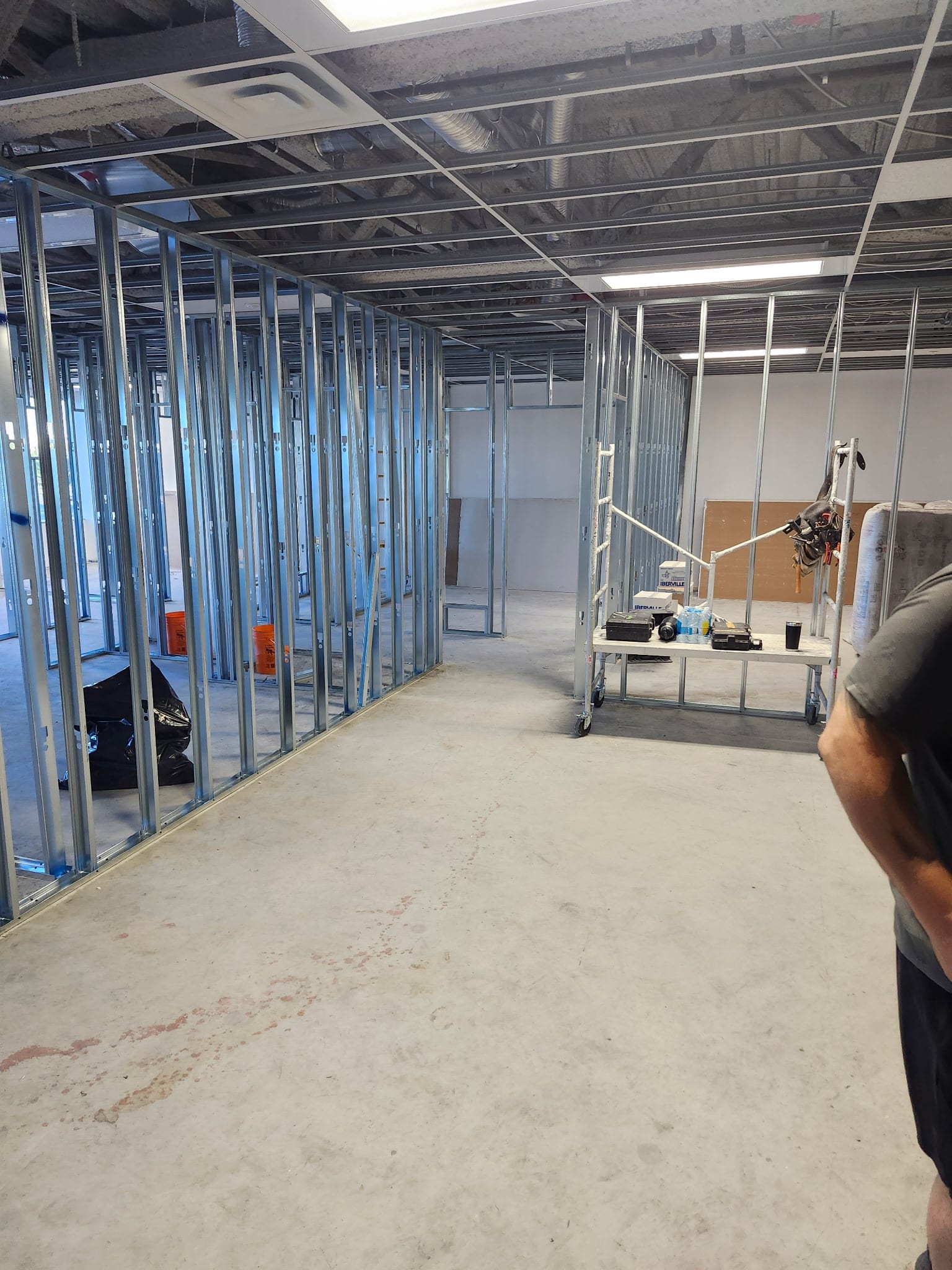 Commercial metal stud framing with T-bar ceiling grid and scaffold